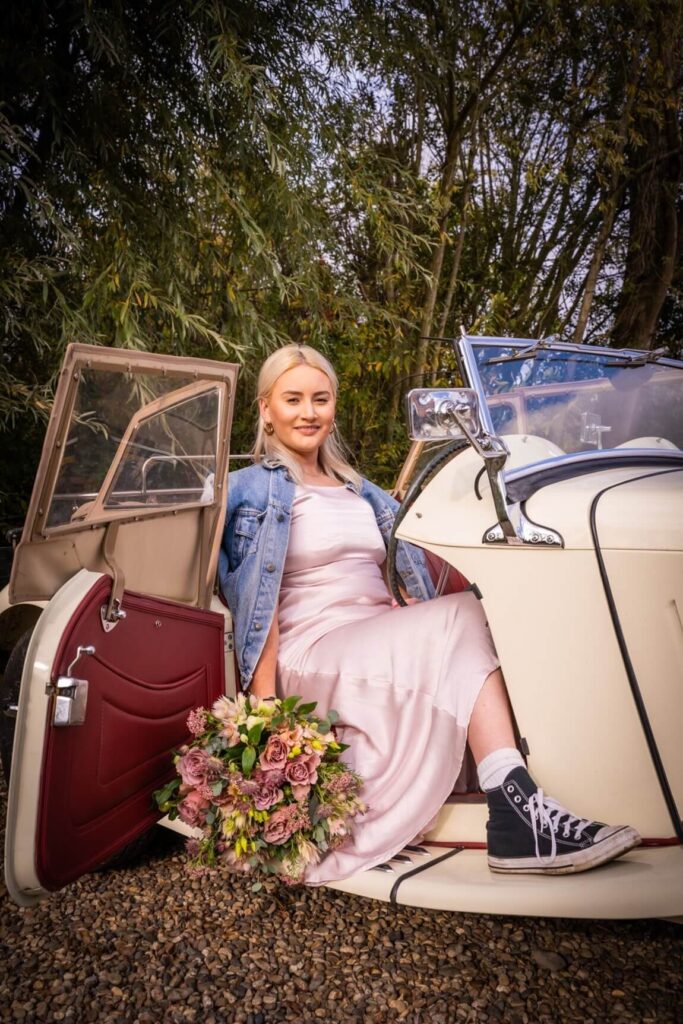 image of bride in wedding car holding a bouquet of flowers